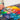 Brush mixing paint on a colourful palette